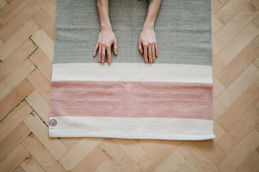 Girl practicing on Organic Cotton yoga rug on wooden floor. 